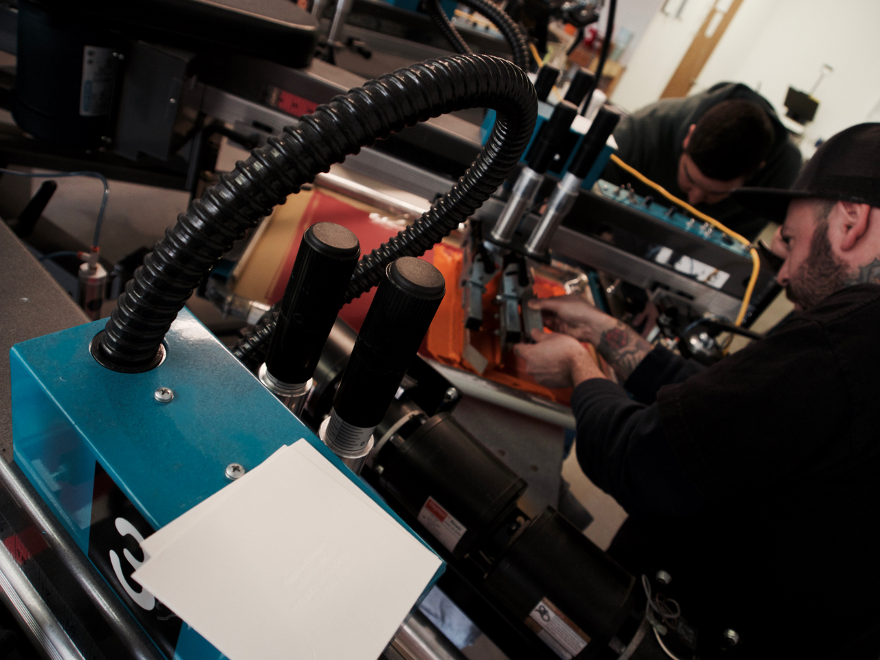 Austin screen printing shop producing custom shirts on press